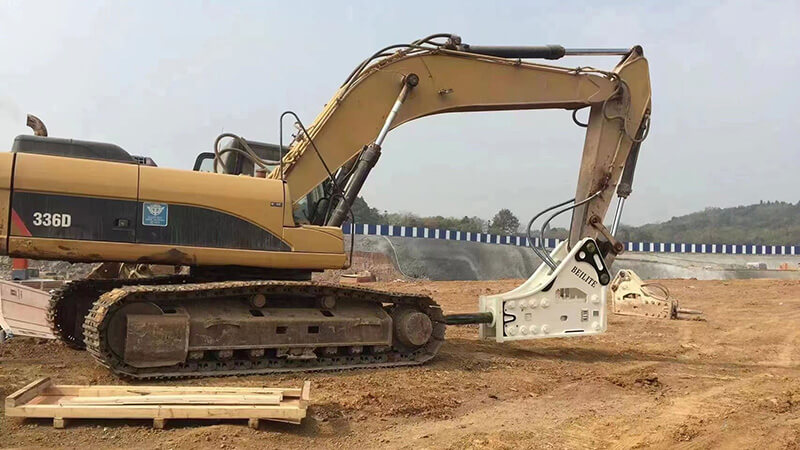 an-excavator-equipped-with-a-white-hydraulic-breaker-on-a-construction-site